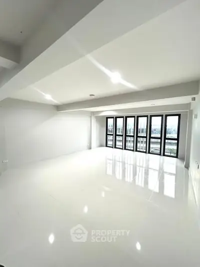 Spacious modern living room with large windows and bright natural light.