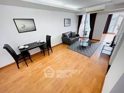 Spacious living room with modern furniture and wooden flooring, perfect for urban living.