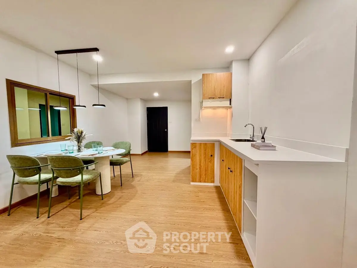Modern open-plan kitchen and dining area with stylish decor and wooden flooring.