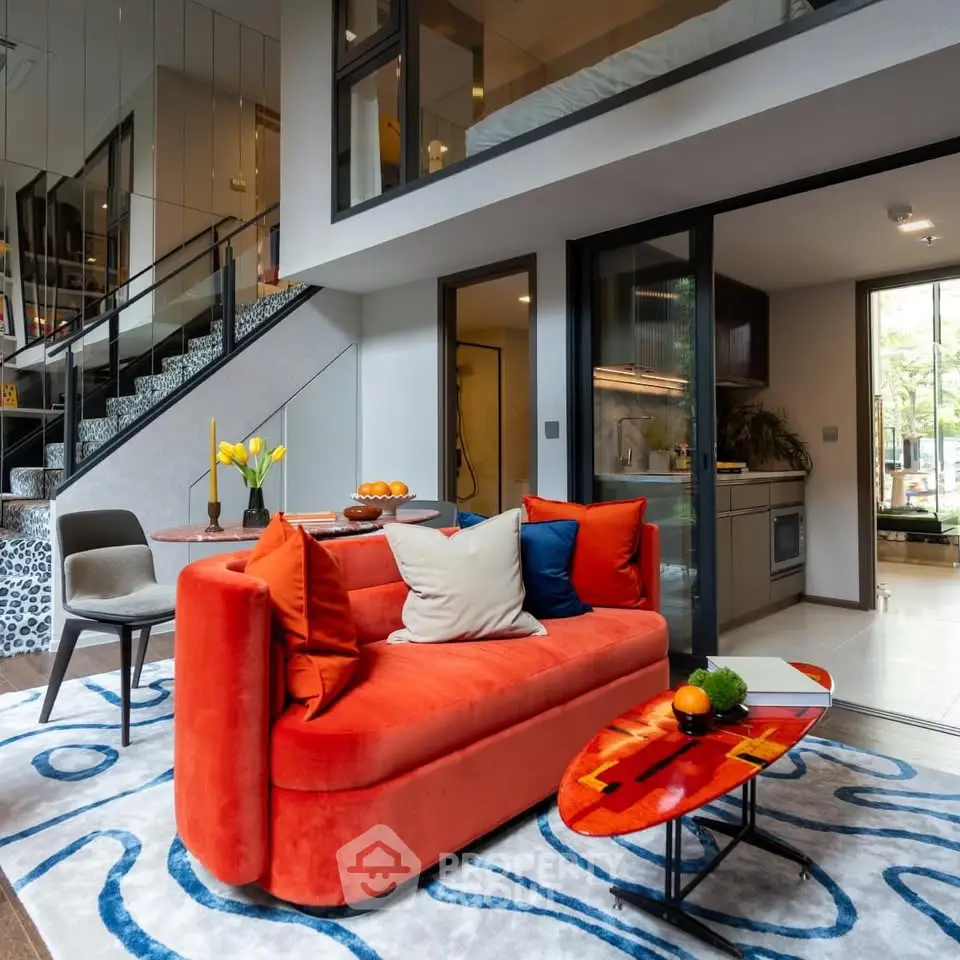 Modern living room with vibrant red sofa and open kitchen layout