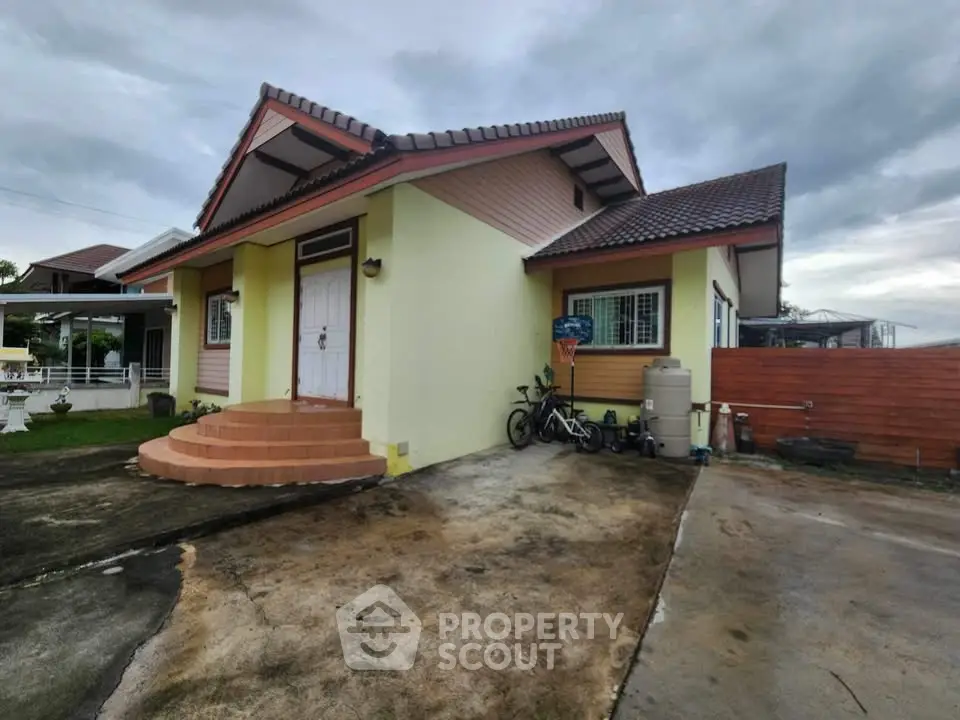 Charming single-story house with a sloped roof and spacious driveway, perfect for family living.