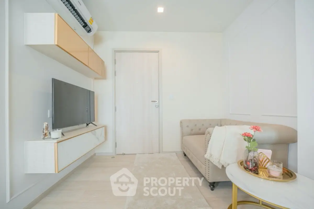 Modern living room with stylish decor and wall-mounted TV, featuring a cozy sofa and elegant design.
