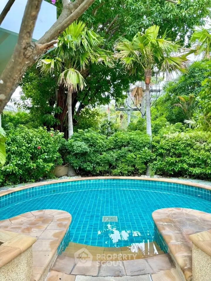 Tropical oasis with a serene private pool surrounded by lush greenery and palm trees.