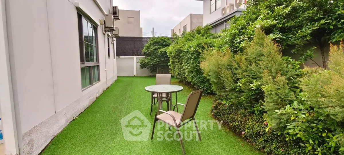 Charming garden area with lush greenery and outdoor seating, perfect for relaxation.
