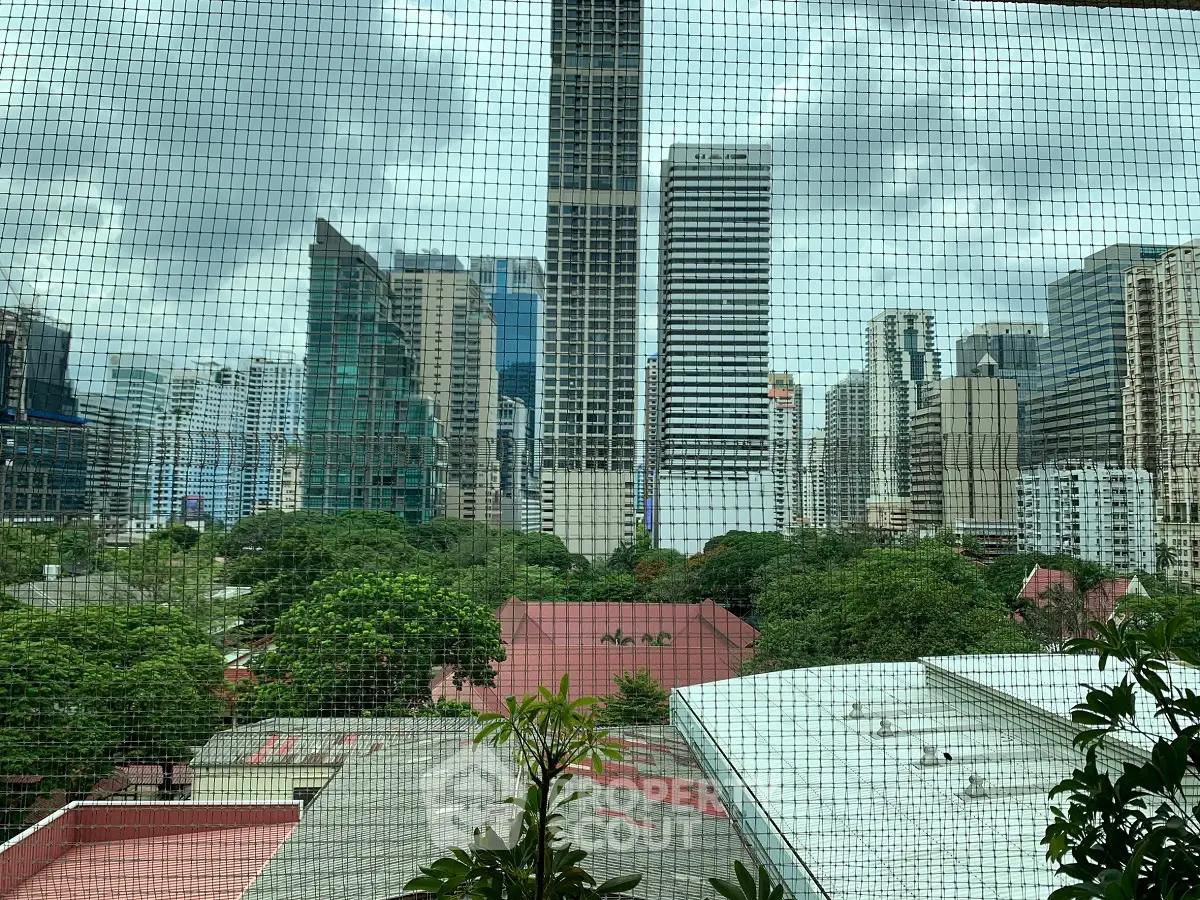 Stunning cityscape view from a high-rise apartment with lush greenery and modern skyscrapers.
