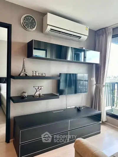 Modern living room with sleek black furniture and air conditioning, featuring a balcony view.