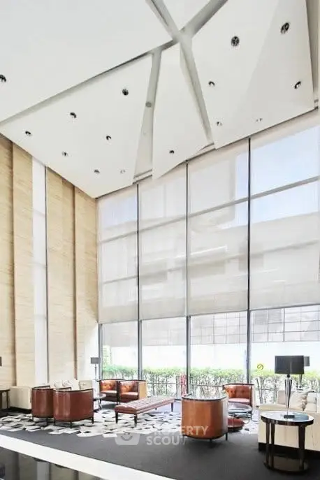 Luxurious modern lobby with high ceilings and elegant seating area in upscale building.