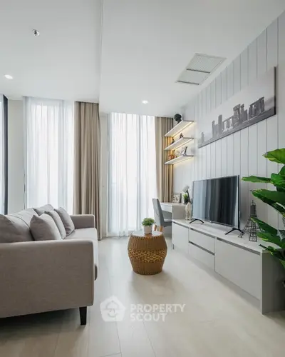 Modern living room with stylish decor, large windows, and comfortable seating in a bright apartment.