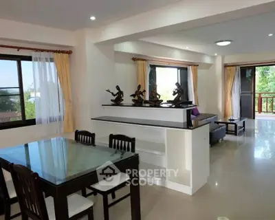 Spacious open-plan living and dining area with elegant decor and large windows.