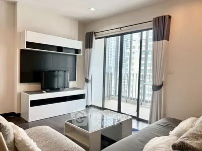 Modern living room with sleek furniture and large balcony view in urban apartment.