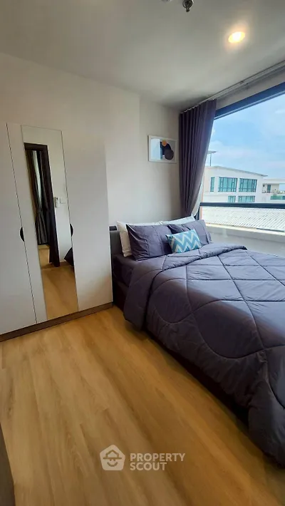 Modern bedroom with large window and stylish decor in urban apartment