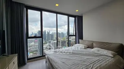 Luxurious bedroom with stunning city skyline view through floor-to-ceiling windows, perfect urban living.