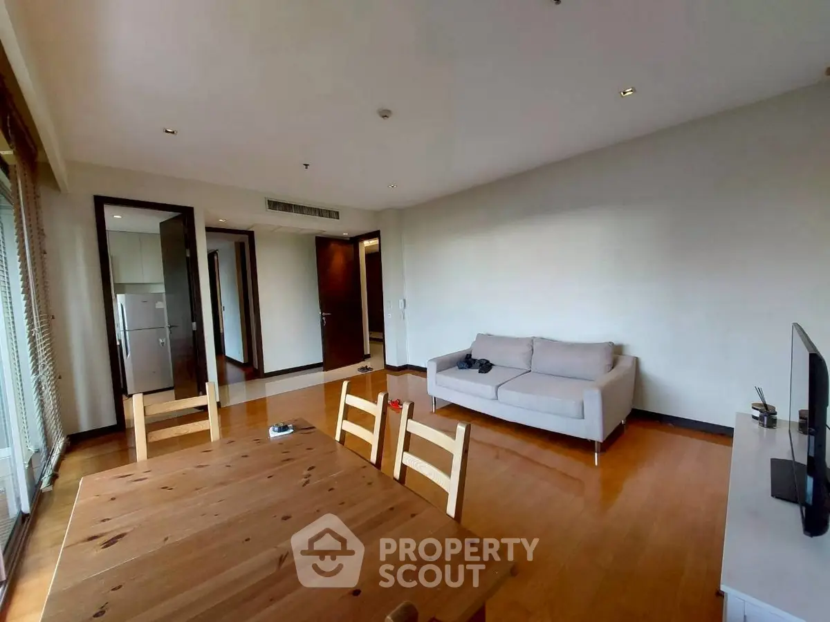 Spacious living room with wooden flooring and modern furniture in a stylish apartment.