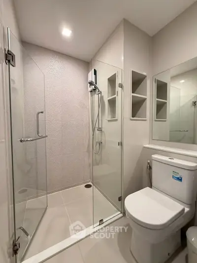 Modern bathroom with glass shower enclosure and sleek fixtures