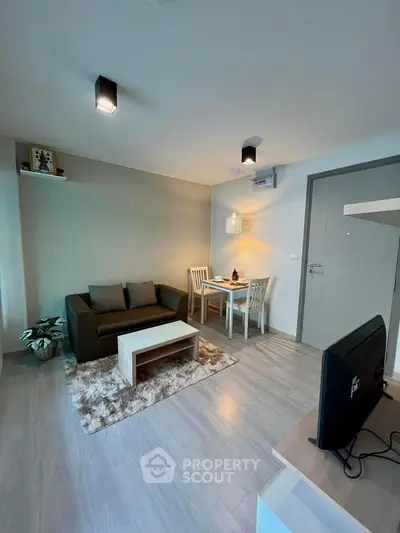 Modern living room with cozy seating and dining area, stylish decor, and warm lighting.