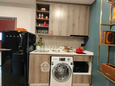 Modern kitchen with washing machine, SMEG fridge, and stylish cabinetry.