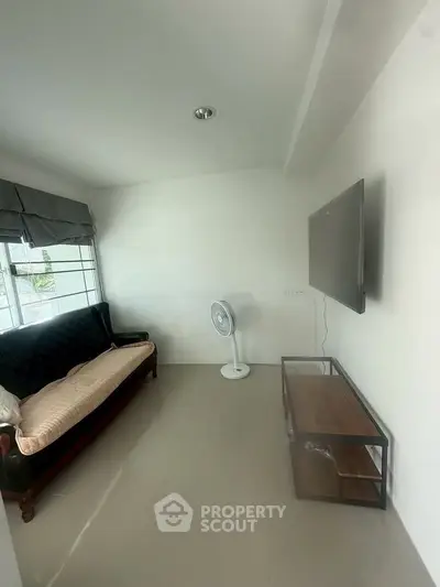 Cozy living room with modern TV setup and comfortable seating, perfect for relaxation.