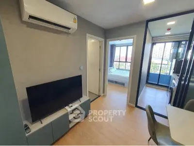 Modern apartment interior with living room and bedroom view, featuring sleek design and natural light.