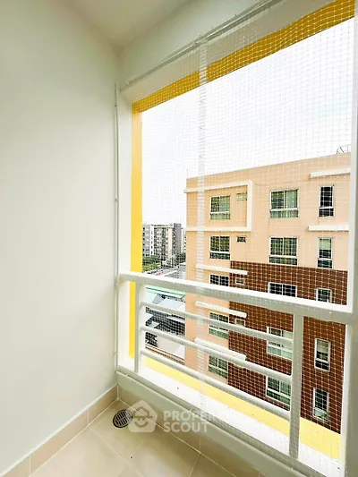 Charming balcony with safety netting and city view in modern apartment building.