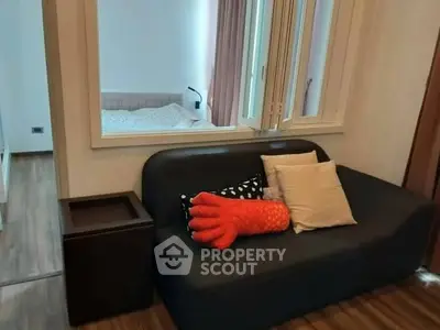 Cozy living room with sofa and view into bedroom