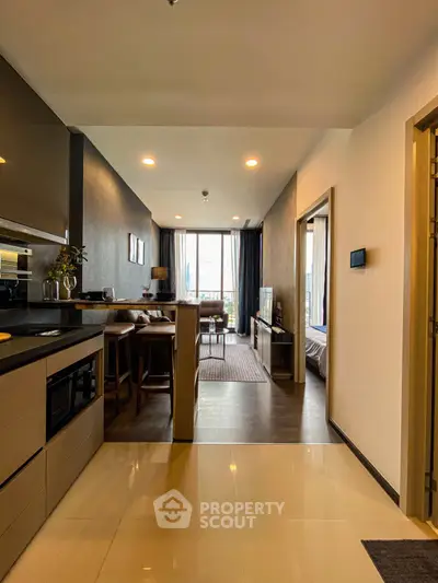 Modern open-layout apartment with sleek kitchen and cozy living area, featuring stylish decor and ample natural light.