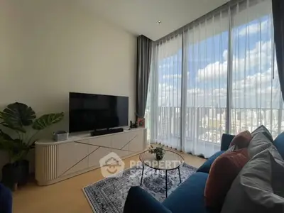 Modern living room with large windows offering stunning city views, stylish furniture, and elegant decor.