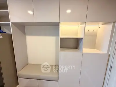 Modern built-in storage unit with sleek cabinets and cushioned seating in a contemporary home.