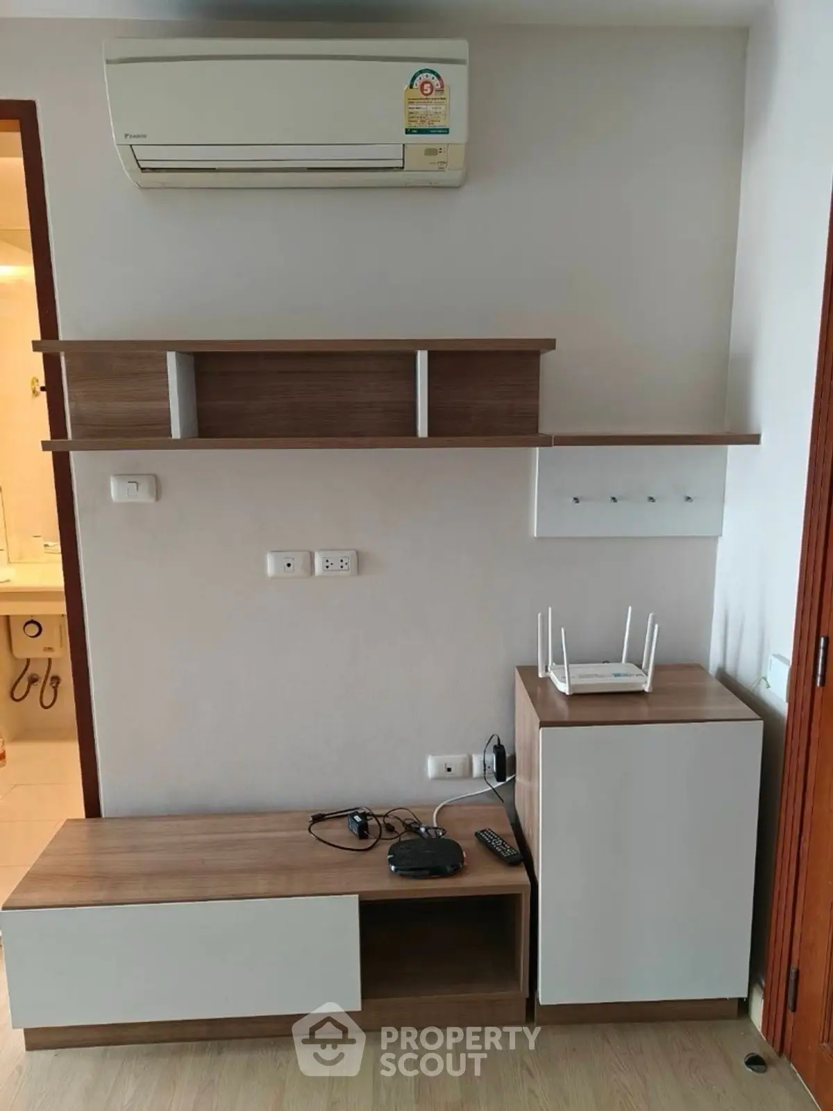 Modern living room with sleek wooden furniture and air conditioning unit