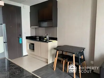 Modern kitchen with sleek black countertops, built-in oven, and a cozy dining area, perfect for urban living.