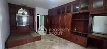 Spacious bedroom with built-in wooden cabinets and ample natural light.