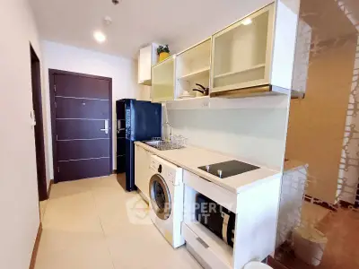 Modern kitchen with sleek appliances and washing machine in stylish apartment.