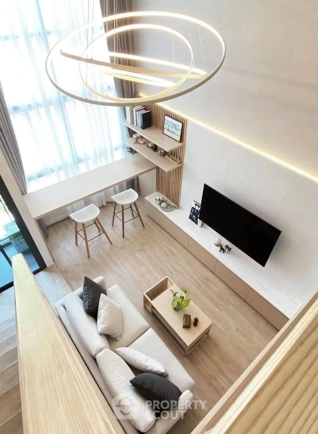 Modern living room with high ceiling and stylish lighting, featuring a cozy sofa and sleek TV setup.