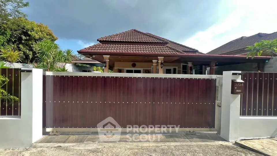 Charming single-story home with a gated entrance and lush greenery, perfect for privacy and tranquility.