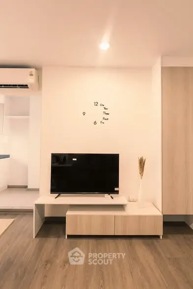 Modern living room with stylish TV setup and elegant wooden flooring.