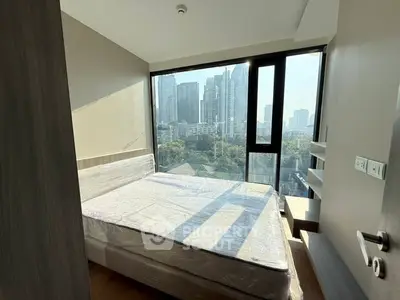 Modern bedroom with large window offering stunning city view