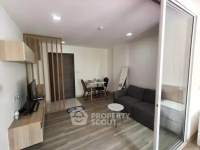 Modern living room with sleek furniture and open layout, featuring a cozy dining area and stylish decor.