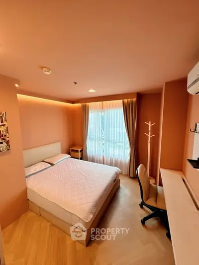 Cozy bedroom with modern decor and natural light, featuring a comfortable bed and workspace.