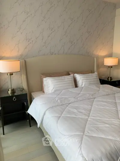 Luxurious bedroom with elegant decor and plush bedding in modern apartment.