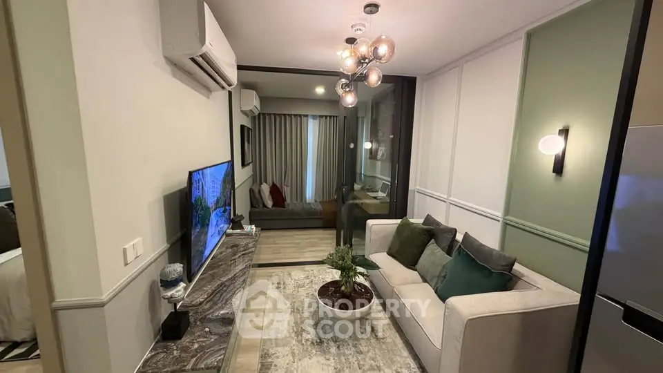Modern living room with stylish decor and open view to bedroom, featuring chic lighting and cozy ambiance.