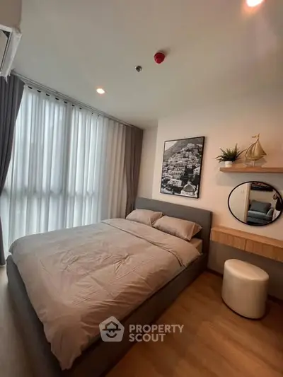 Modern bedroom with cozy bed, stylish decor, and natural light from large window.