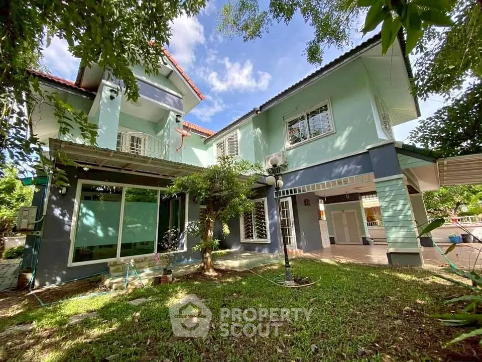 Charming two-story house with lush garden and spacious outdoor area, perfect for family living.