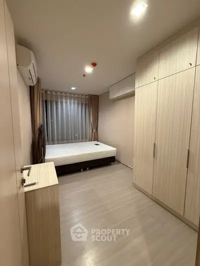 Spacious bedroom with modern furnishings and ample storage in a stylish apartment.