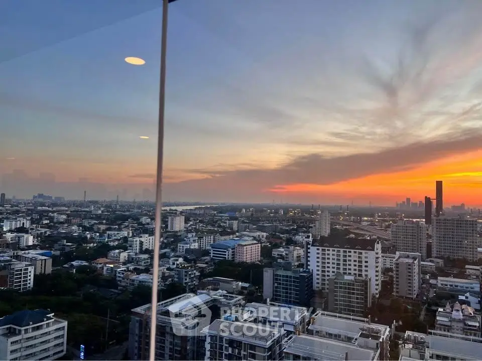 Stunning cityscape view from high-rise building at sunset, showcasing urban skyline and vibrant sky.