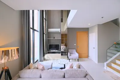Luxurious modern living room with high ceilings and elegant decor in a stylish apartment.