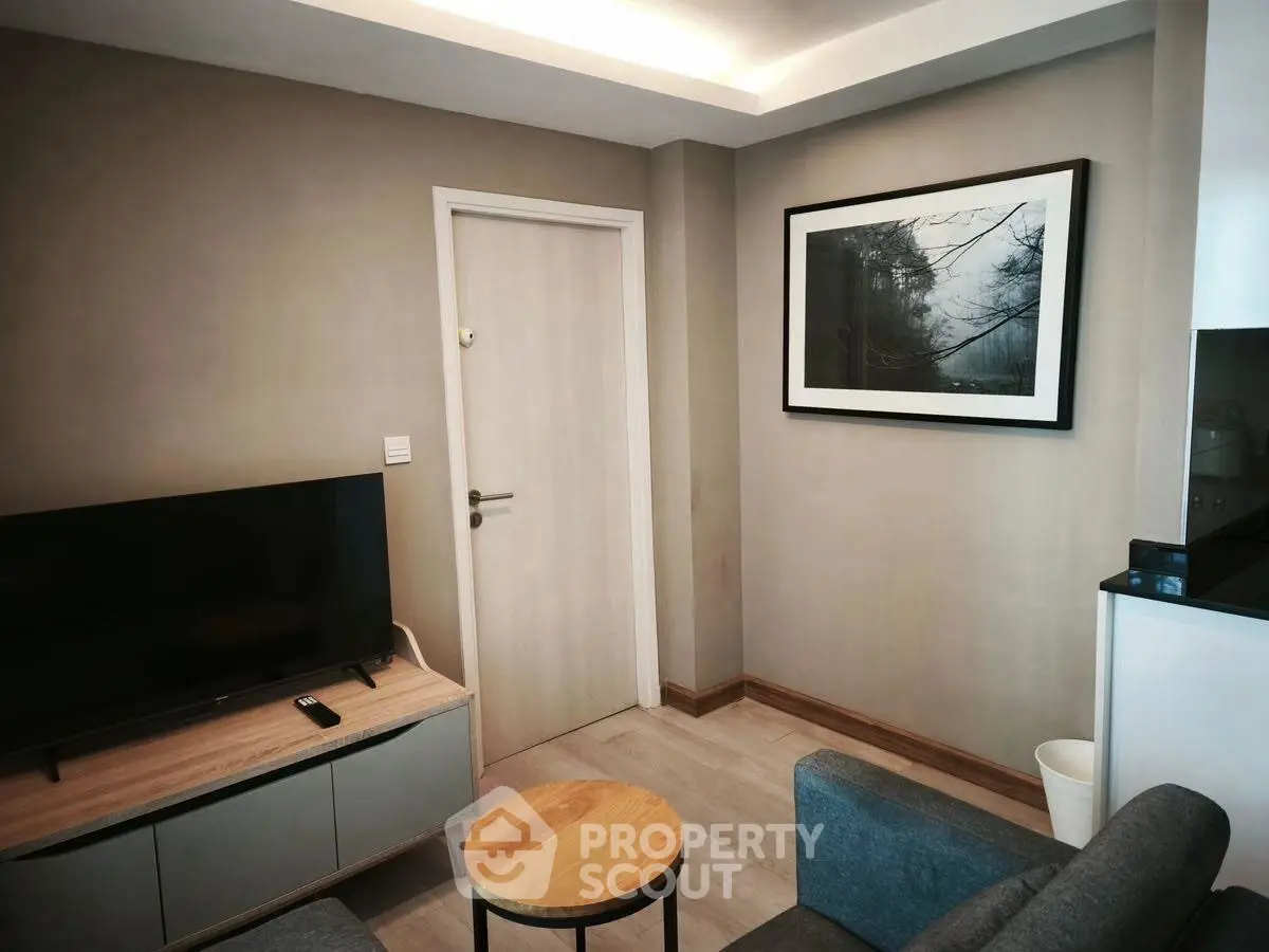 Cozy living room with modern decor and wall art, featuring a sleek TV setup.