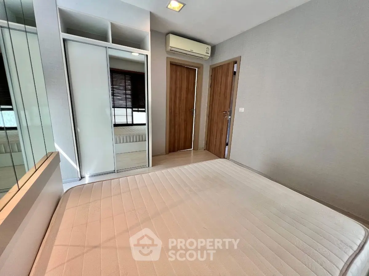 Modern bedroom with mirrored wardrobe and air conditioning unit