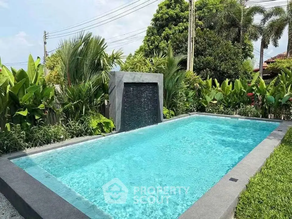 Luxurious outdoor pool surrounded by lush greenery, perfect for relaxation and leisure.