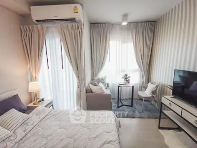 Chic modern bedroom with cozy seating area and natural light, perfect for relaxation and comfort.