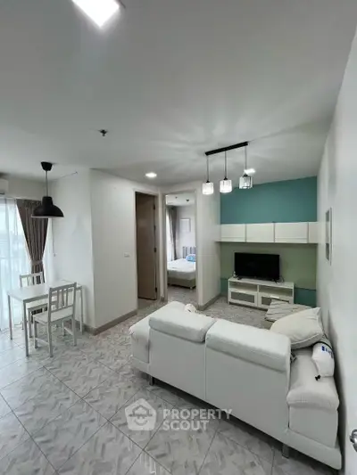 Modern living room with stylish decor and open layout, featuring a cozy dining area and elegant lighting.
