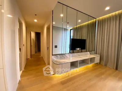 Modern living room with elegant wood flooring and stylish mirrored wall unit